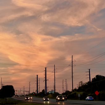 sunset over a road lined with power lines