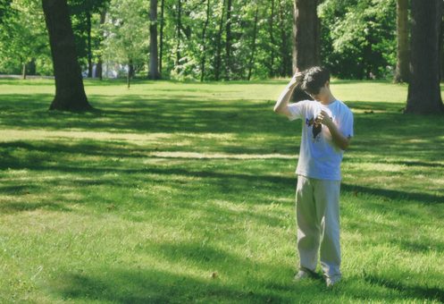 someone taking a photo in a sunlit park